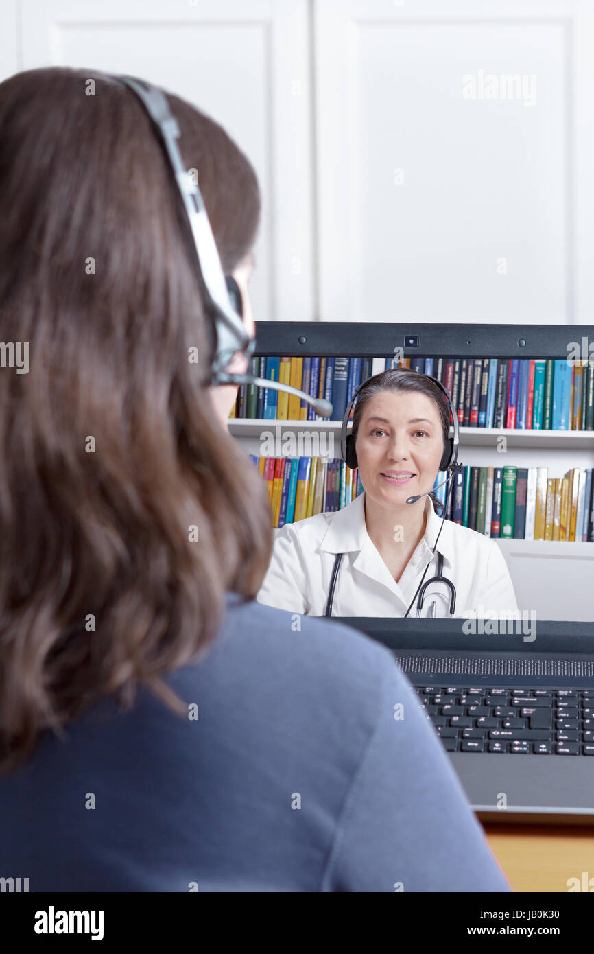 Woman with headset and laptop making a video call with her doctor, copy or text space, e-health, telehealth or telemedicine concept Stock Photo