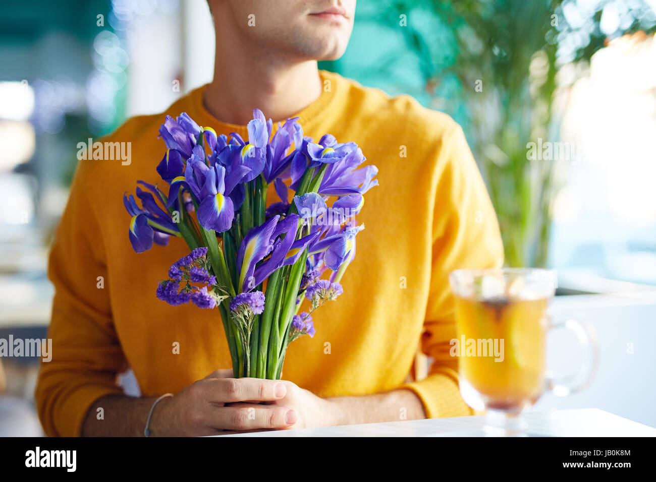 Young Man Holding Flowers Bouquet Stock Photo