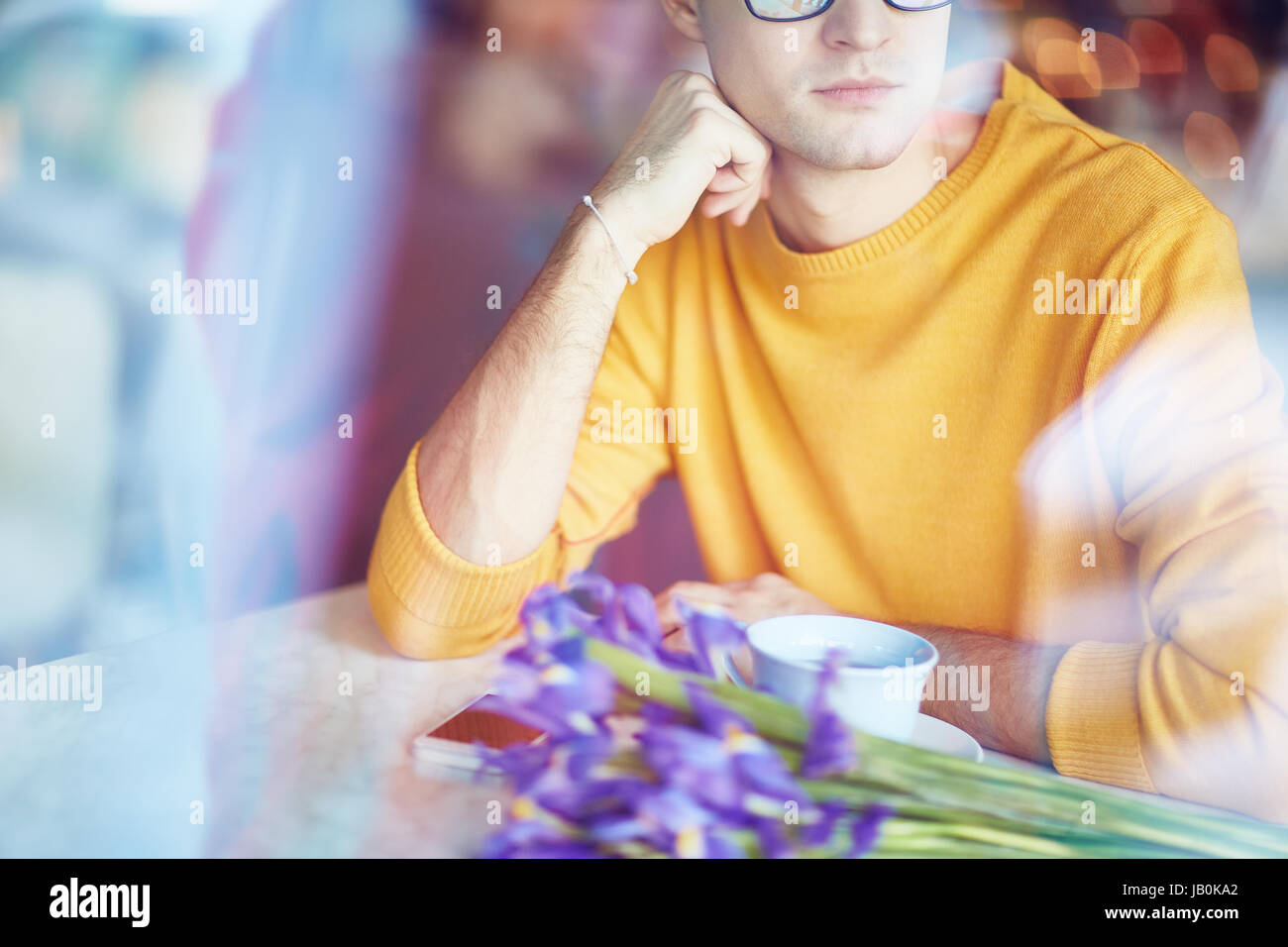 Man with Flowers Waiting in Cafe Stock Photo