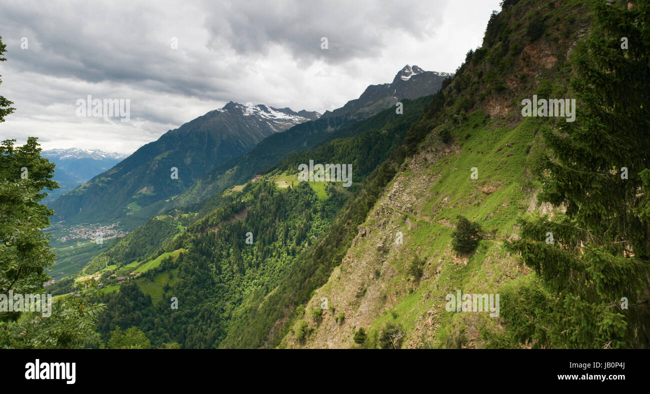 Panorama-Ansicht von der der Seilbahn-Bergstation Hochmuth / Südtirol in das Meraner Tal mit Steilhang und schmalen Fußpfad bei bewölkten Himmel im Sommer 2013 Stock Photo