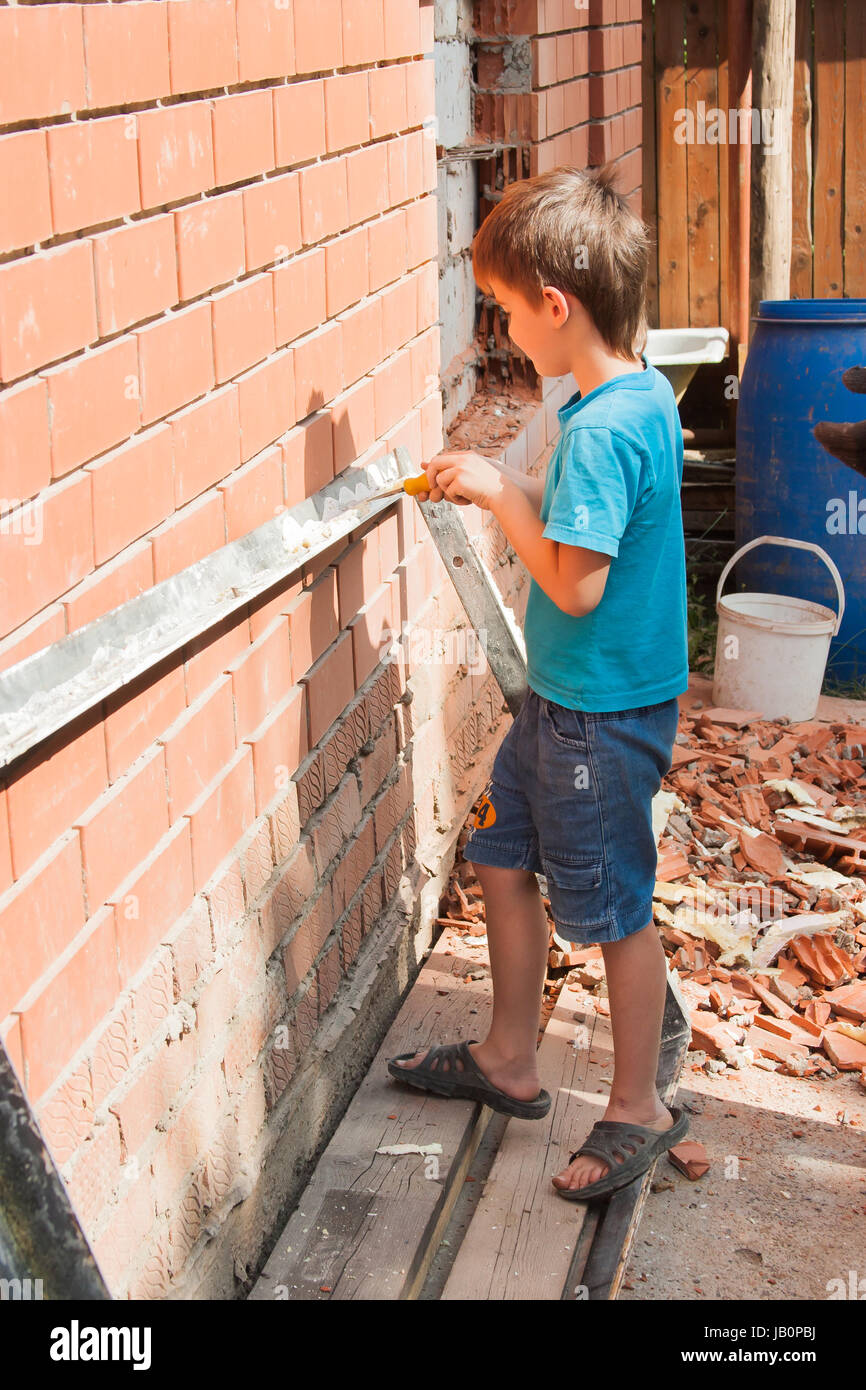 little helper, boy at work near a brick house Stock Photo Alamy