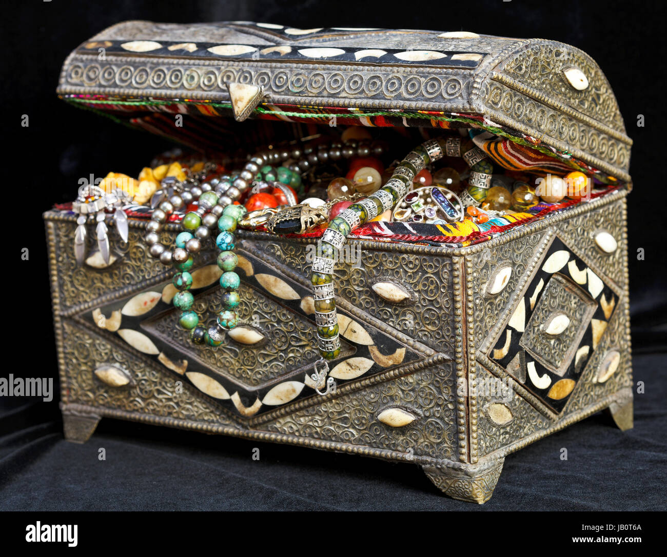 ancient east treasure chest with antique jewelry on black clothes Stock