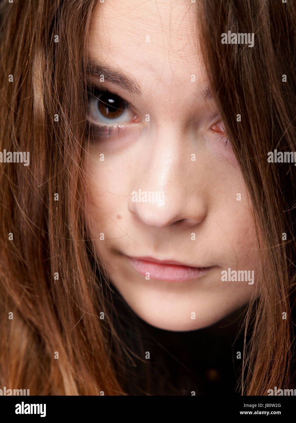 Close-up portrait of a beautiful woman covers the face by long brown hairs Stock Photo