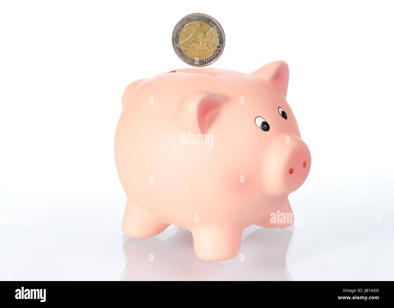 Sparschwein mit 2 Euro Münze vor weißem Hintergrund Stock Photo