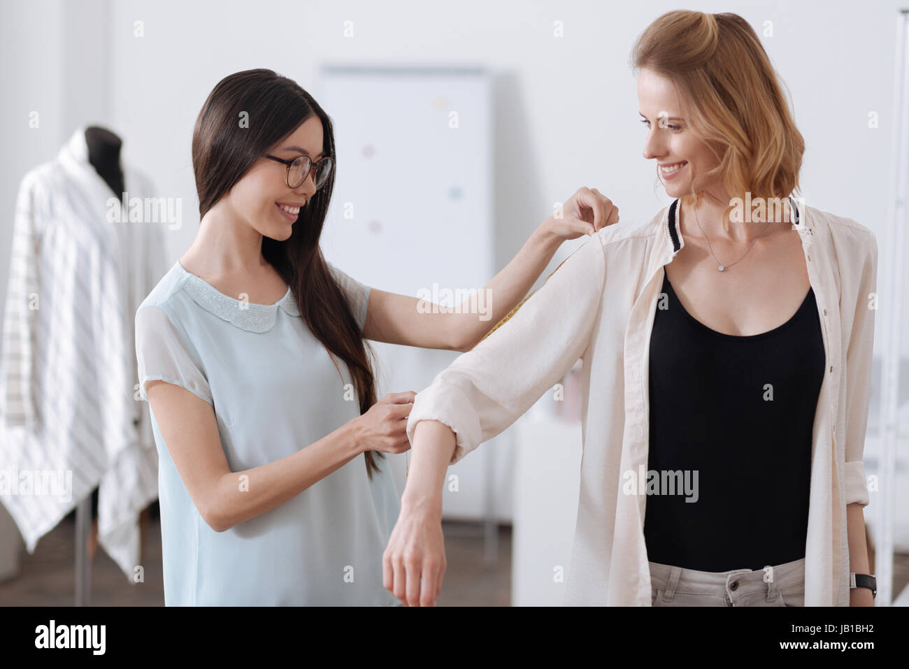 Tailor taking measurements of arm length Stock Photo
