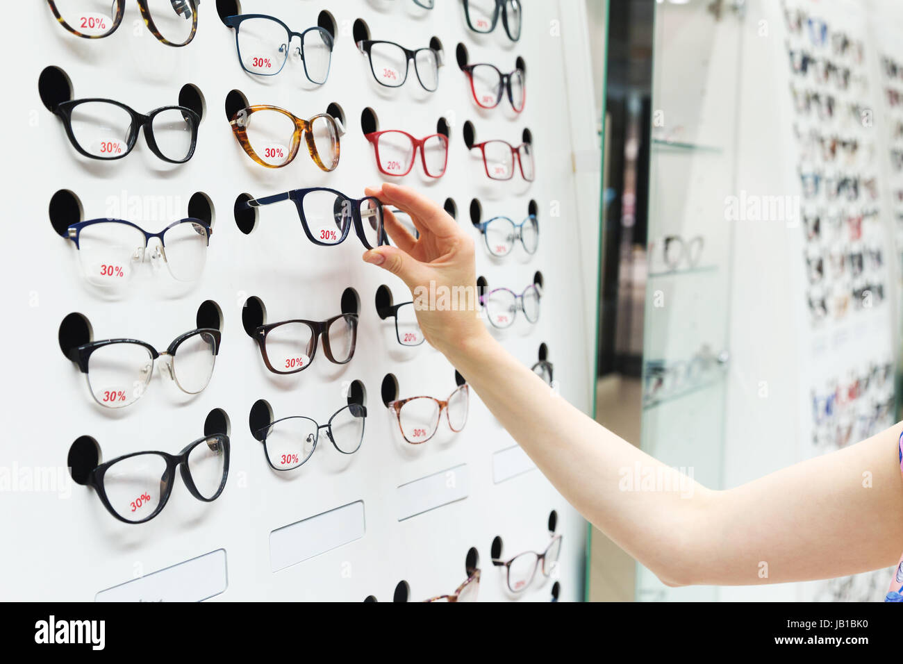 choosing new optical glasses in optician shop Stock Photo