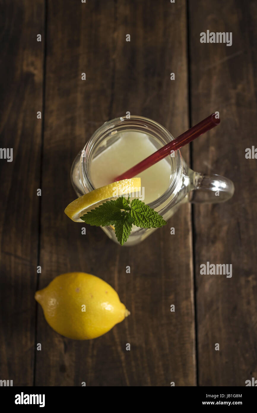 Lemonade glass jar with lemon wedges and straw, from above Stock Photo