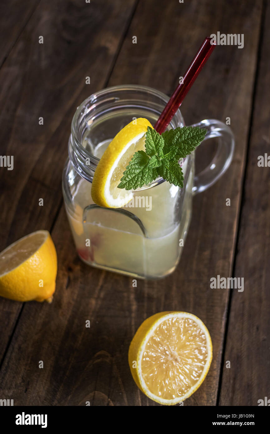 Lemonade glass jar with lemon wedges and straw, from above Stock Photo