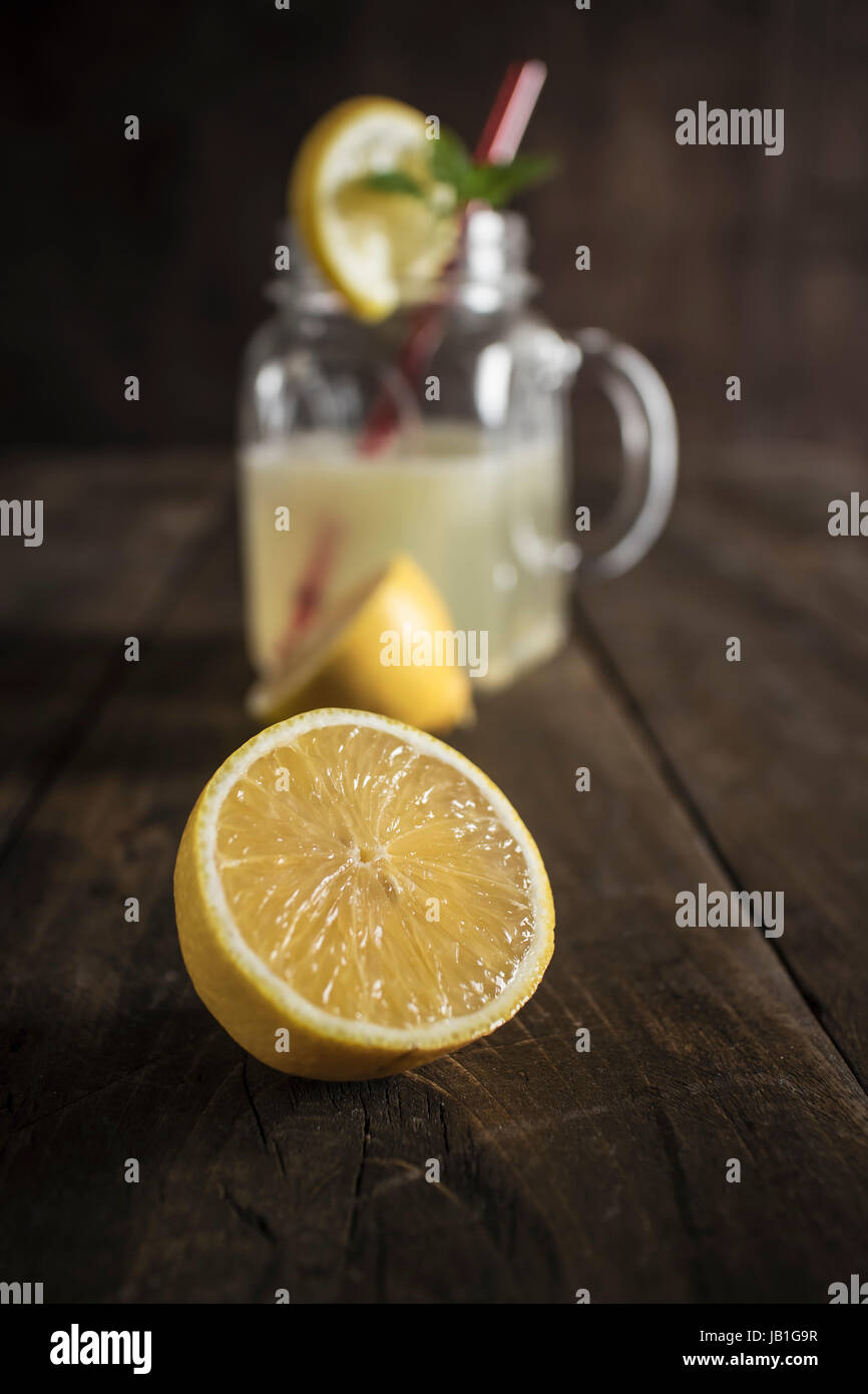 Lemonade glass jar with lemon wedges and straw, close up Stock Photo