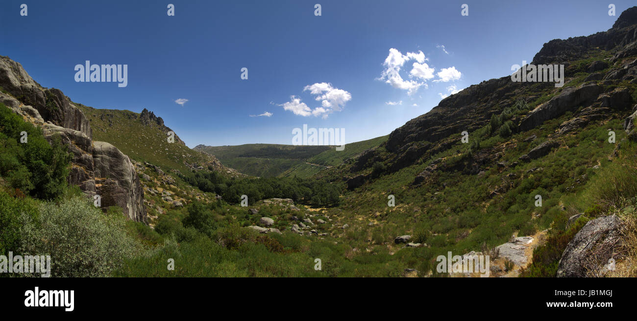 Covao d'Ametade, the beginning of Manteigas glacial valley. Trees and vegetagion amongst mountains and under a blue sky. Estrela mountain range (Serra Stock Photo