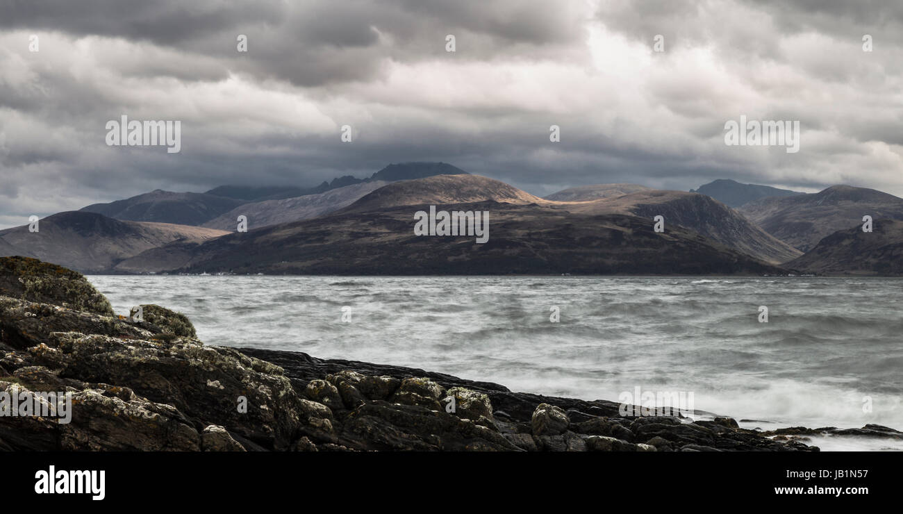 Panoramic photograph of Isle of Arran from the Kintyre shoreline as the weather looks threatening Stock Photo