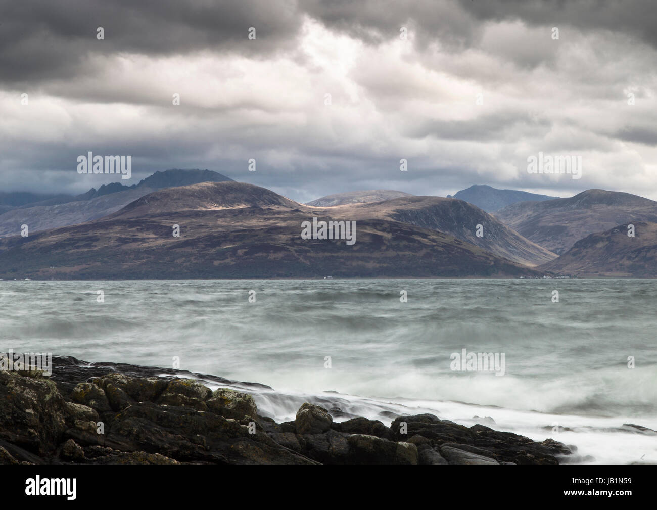 Arran seen from Kintyre shoreline in dramatic weather Stock Photo