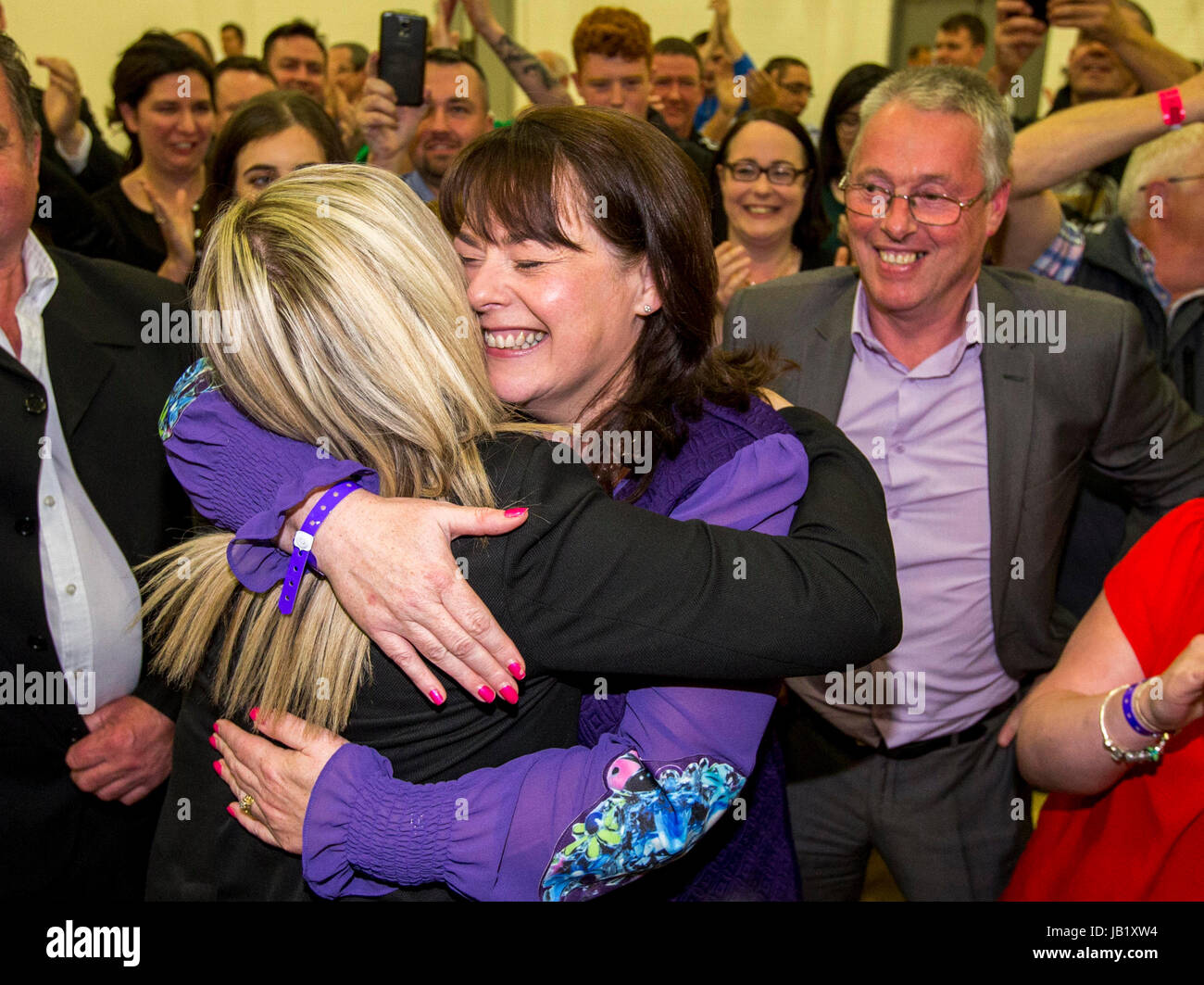 Newly elected Sinn Fein Fermanagh & South Tyrone MP Michelle Gildernew (centre) is embraced on by Michelle O'Neill (left), as Sean Lynch looks on (right) at the Omagh Leisure Complex, Co Tyrone. Stock Photo