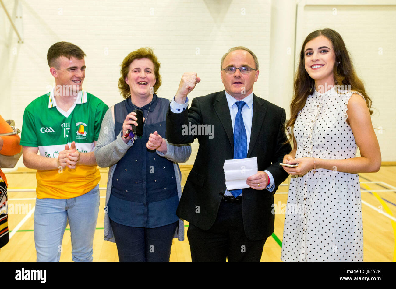 Newly elected Sinn Fein MP for West Tyrone Barry McElduff MP (second from right) rises his fist in celebration with his family, son Patrick (left), wive Paula (second from left) and daughter Niamh (right) at the Omagh Leisure Complex, Co Tyrone. Stock Photo