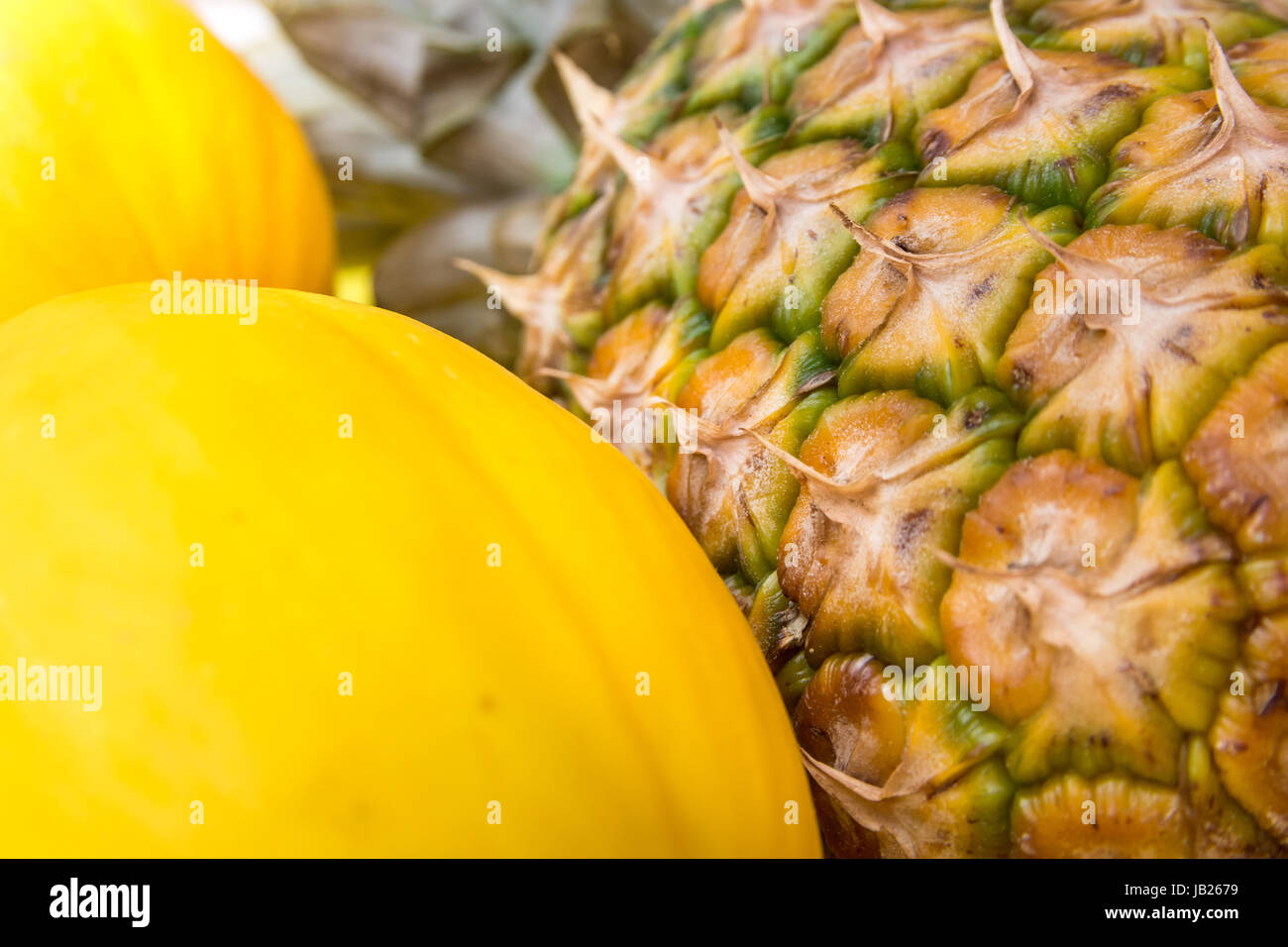 Ripe pine-apple bunch of yellow melons on farmer's market, Asia, skin texture, close up, vibrant colors Stock Photo
