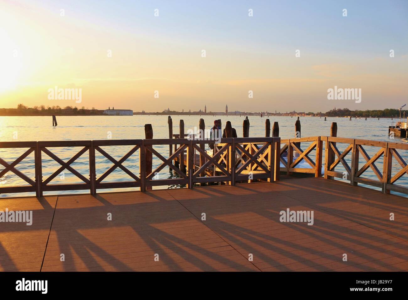Promenade and landing stage on the lagoon of Venice at sunset. On Lido ...