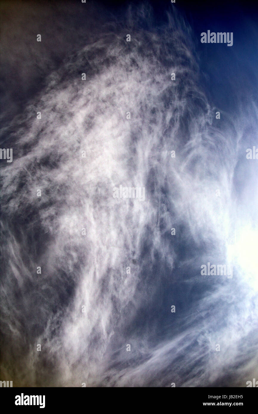 facial Pareidolia blue sky with white clouds that look like  hairy wispy old man Stock Photo