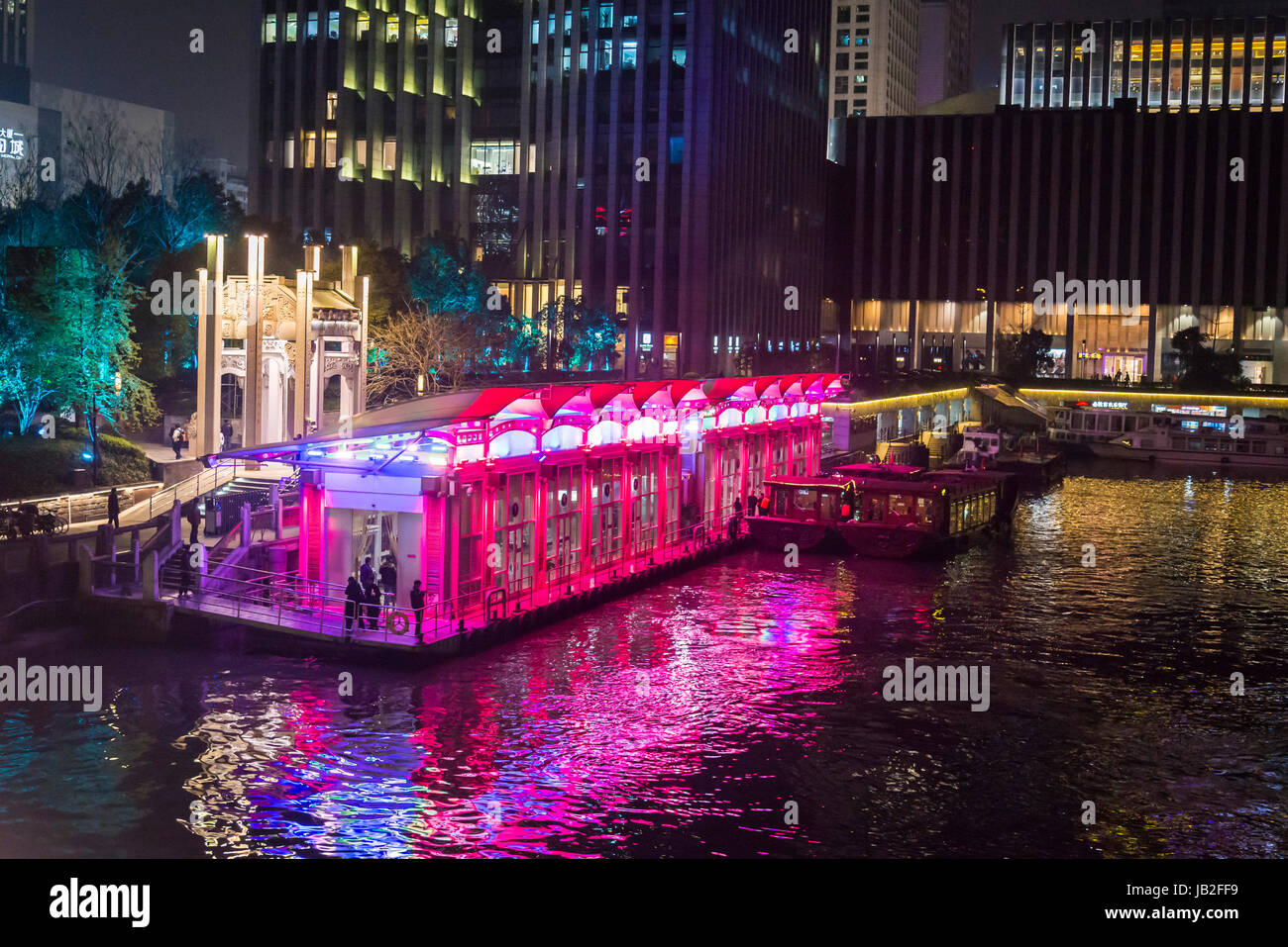 Illuminated Grand Canal pier and commercial skyscrapers beyond it, Hangzhou, Zhejiang province,  China Stock Photo