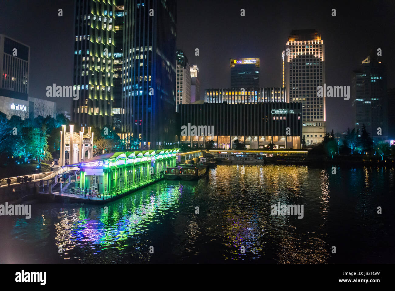 Illuminated Grand Canal pier and commercial skyscrapers beyond it, Hangzhou, Zhejiang province,  China Stock Photo