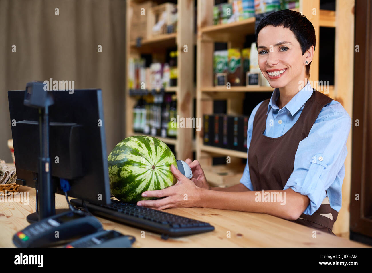 Pretty Cashier at Wooden Counter Stock Photo