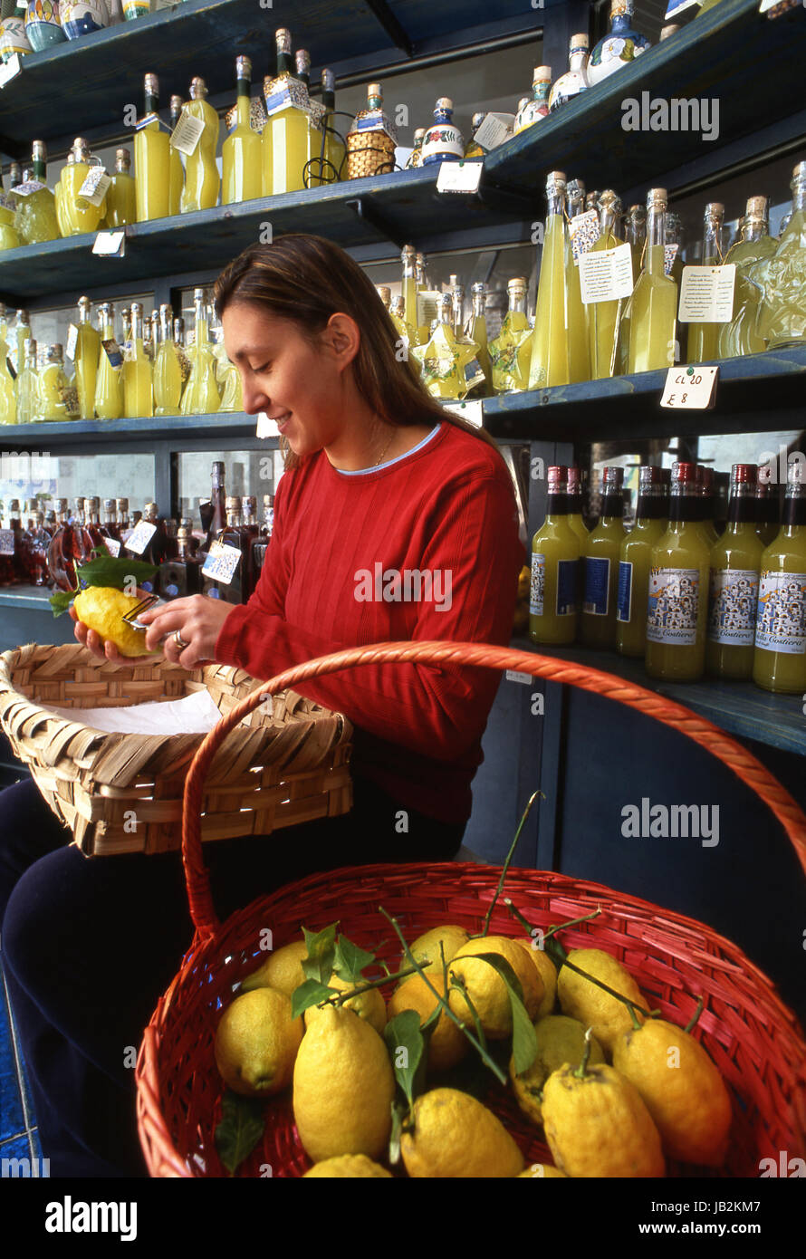 Limoncello, Amalfi lemons with girl peeling the skins to produce aromatic  Liquore al Limone, in Profumi della Costiera, Ravello, Campania, Italy. Stock Photo