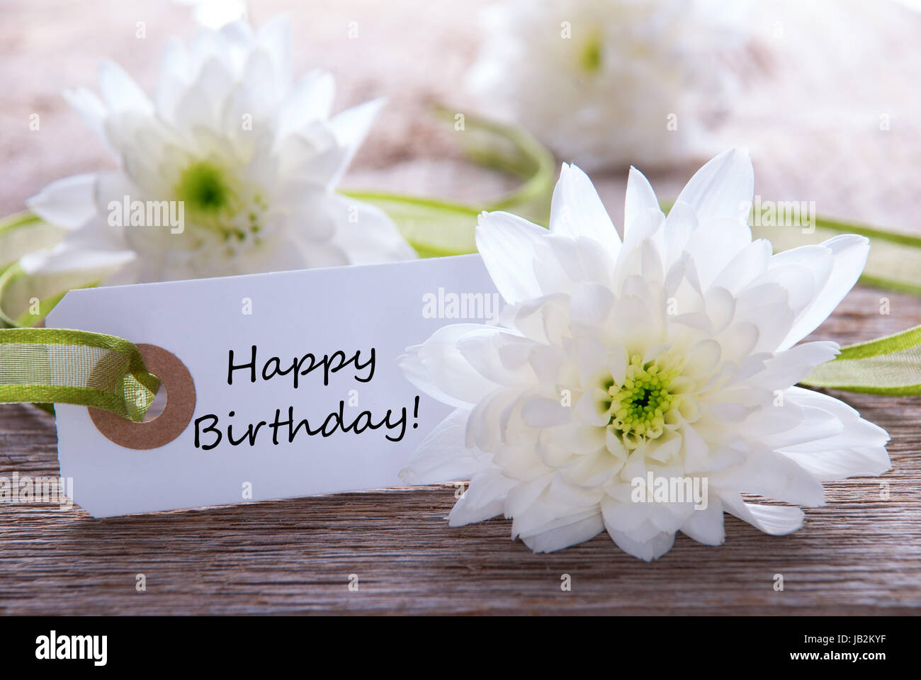 A White flower Background with a Label with Happy Birthday on it Stock