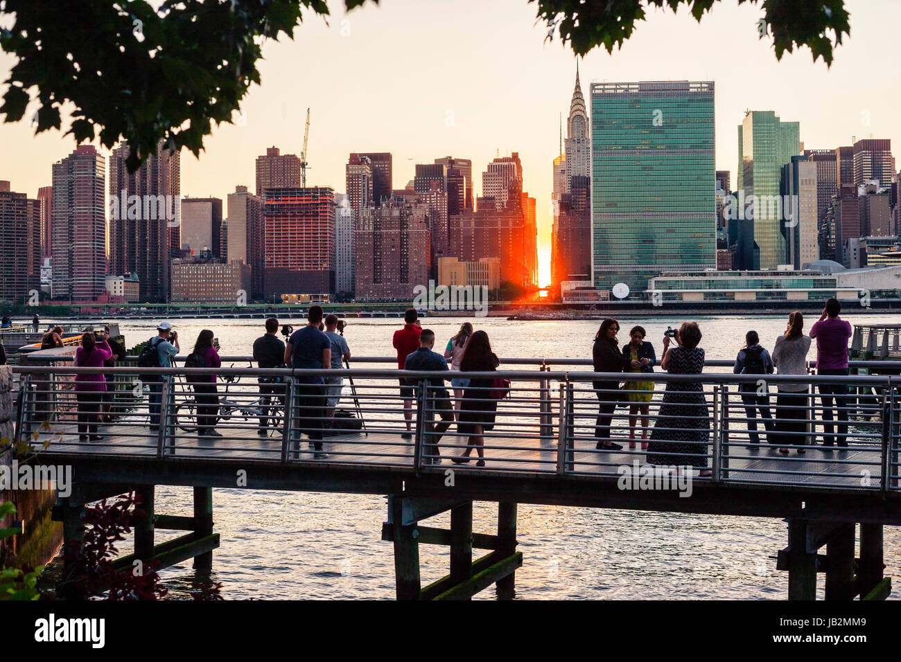 People watching sunset between buildings on Manhattan in New York City Stock Photo
