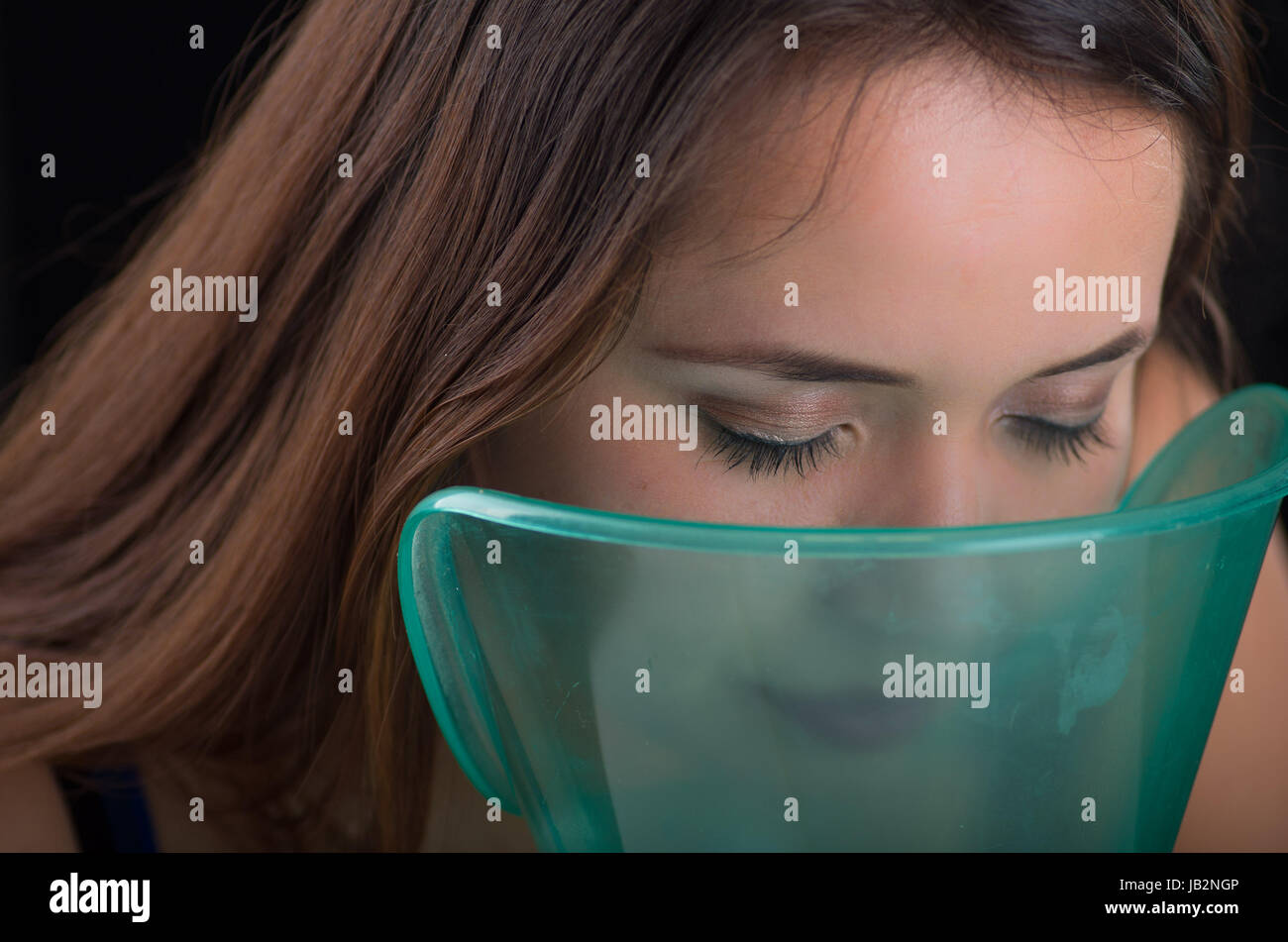 Young woman doing inhalation with a medical vaporizer nebulizer machine