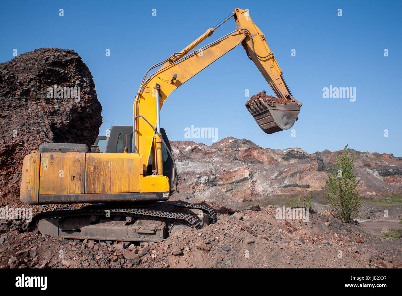 A large construction excavator of yellow color on the construction site ...