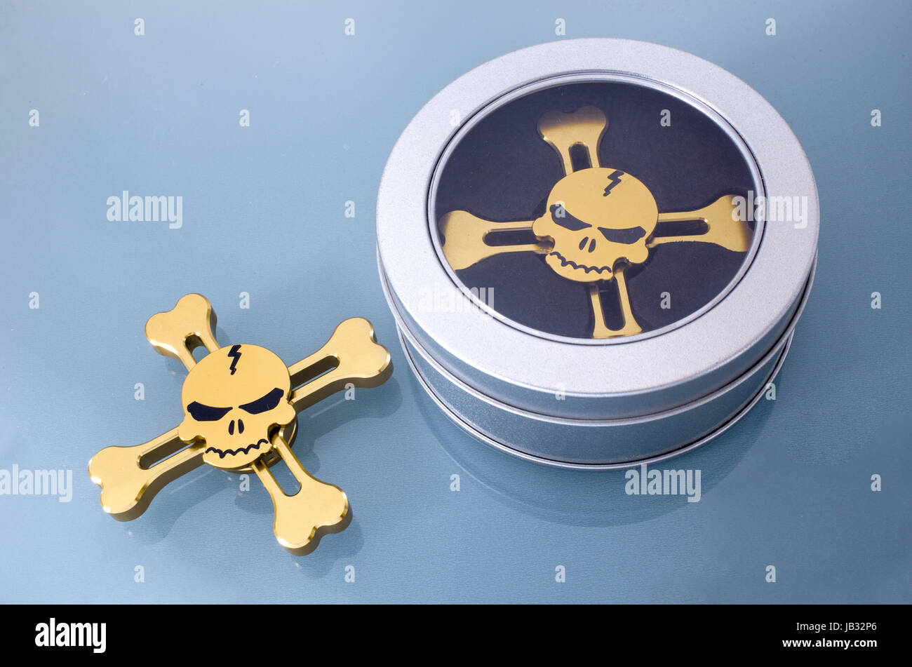 Golden spinner in the form of a skull on a blue background Stock Photo