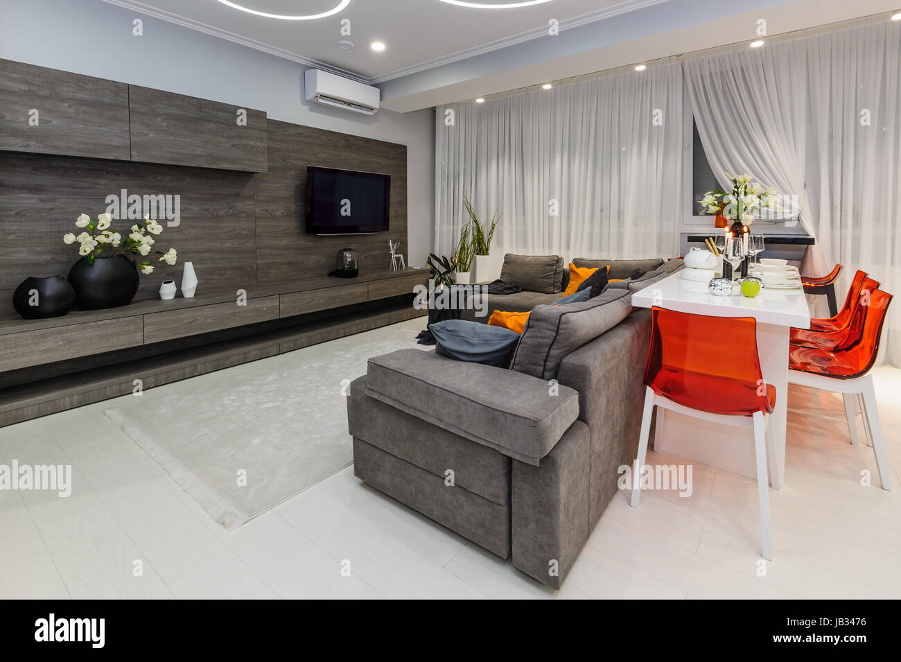 Modern white living room with dining table Stock Photo - Alamy