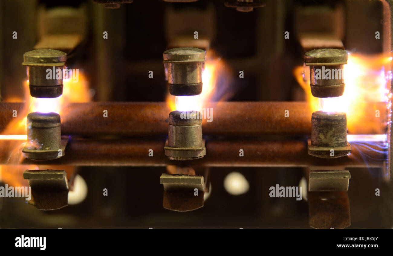 Electric relay with sparks jumping between the contacts, due to breaking a heavy inductive load. Stock Photo