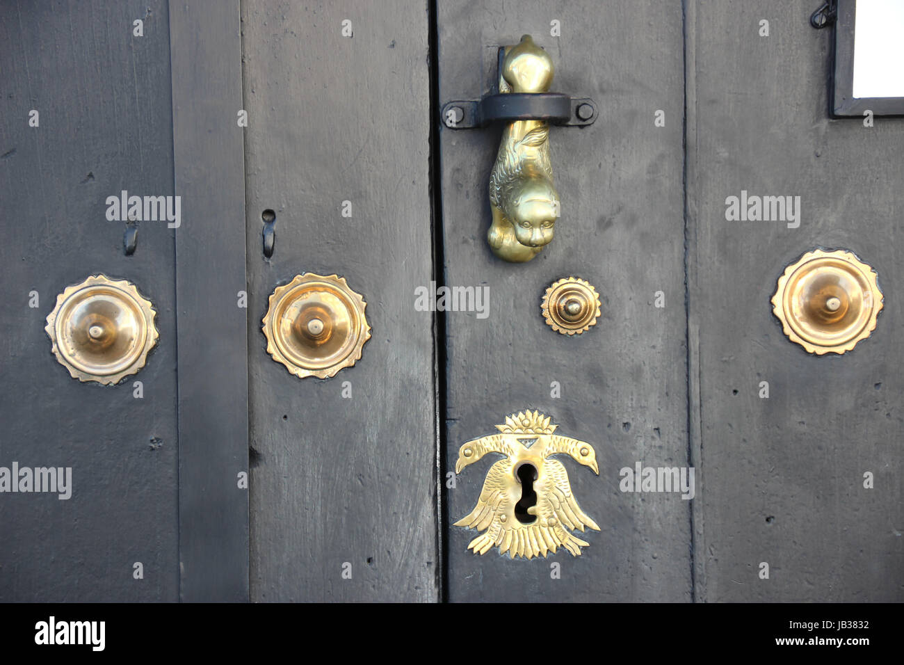 Puerta de madera de La Antigua Guatemala, con detalles y adornos, tocador en forma de león, cerradura y remaches, todo color dorado, estilo colonial Stock Photo