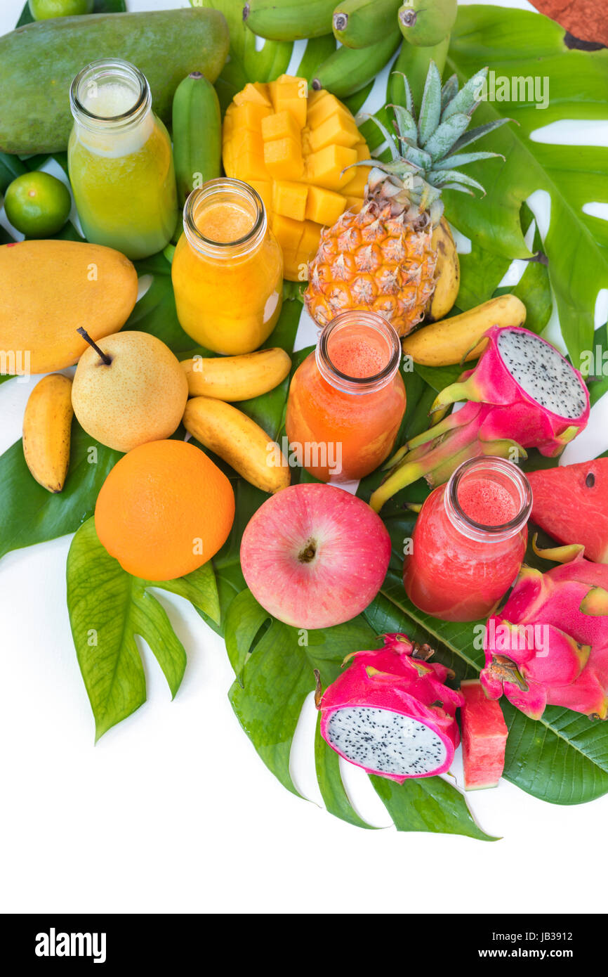 Tropic flat lay top view tropical summer concept with colorful tropical fruits mango pineapple dragon watermelon apple orange banana lime and smoothie Stock Photo