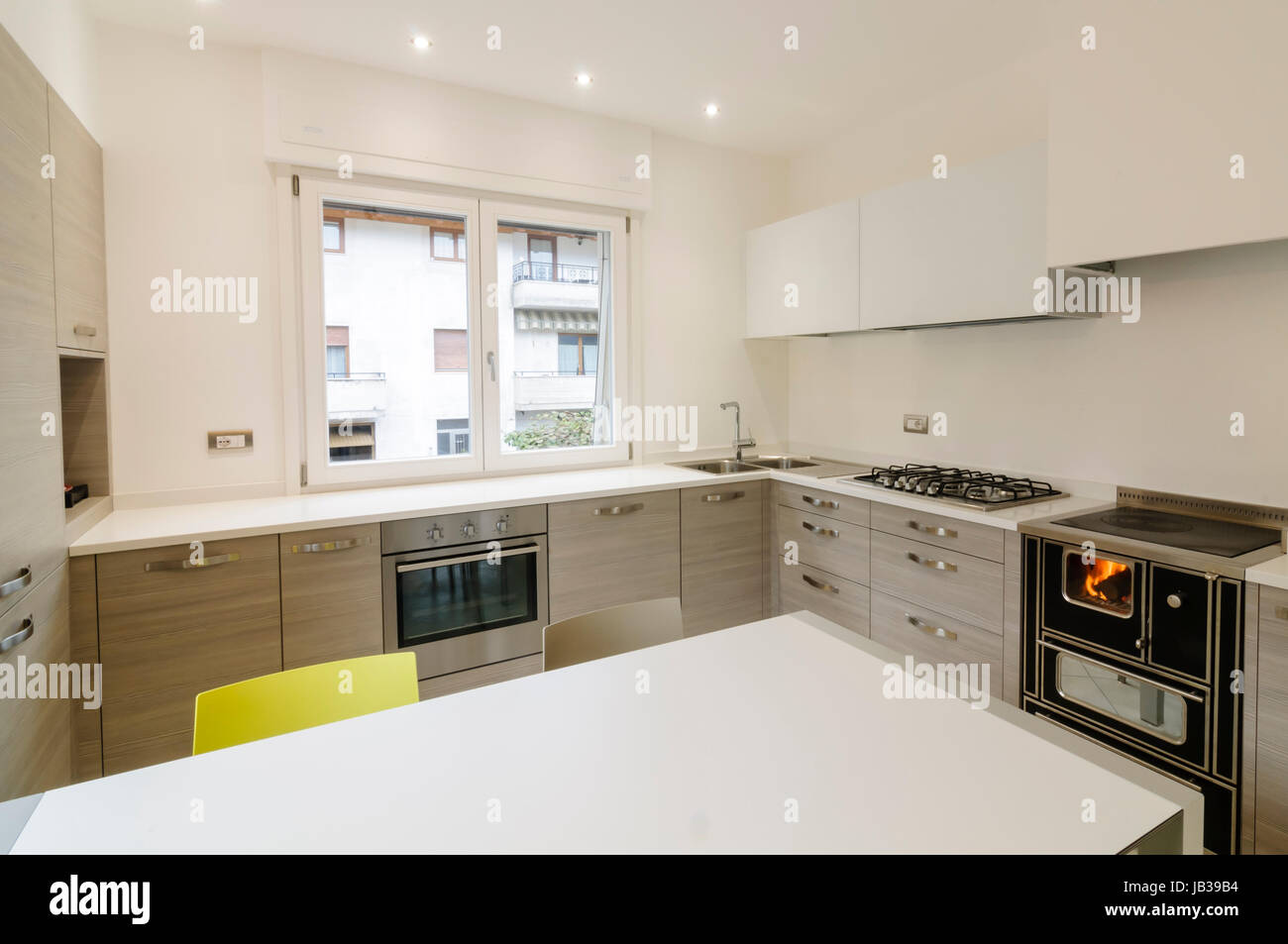 Modern kitchen interior with wooden cabinets and white table Stock Photo