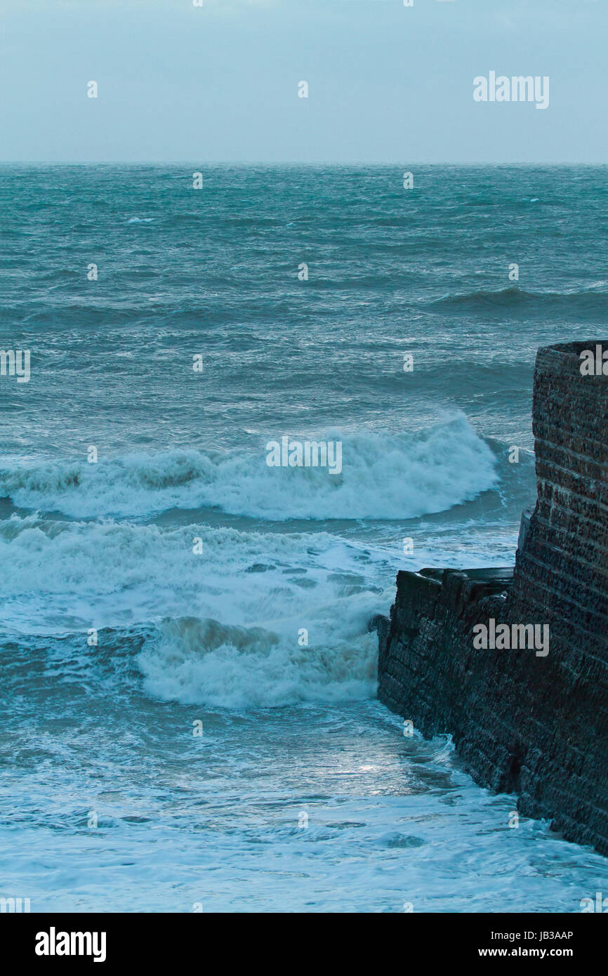 Rough Sea and jetty at dusk on winter day Stock Photo