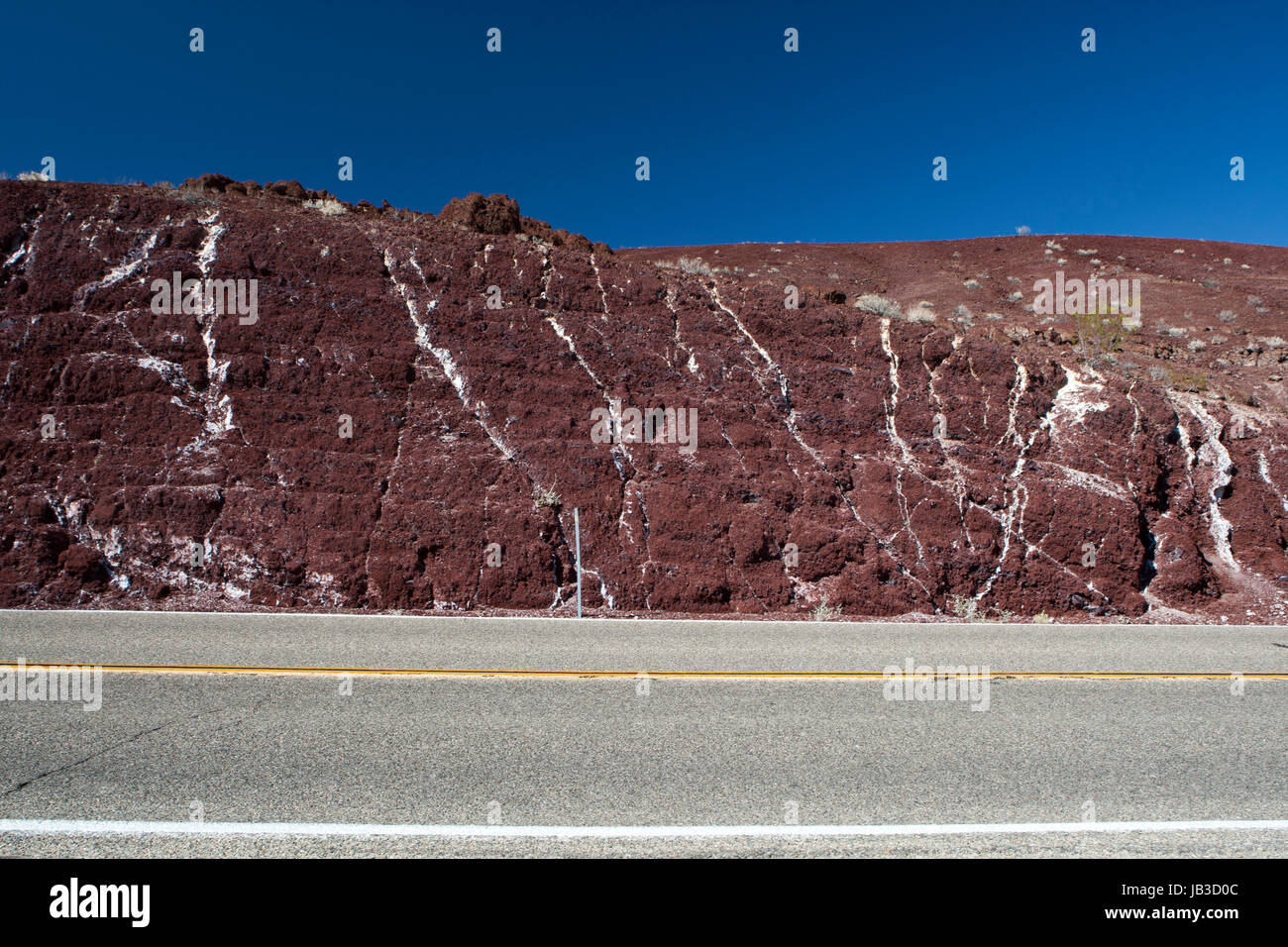 rote Felswand mit weißen Adern an einer Straße im Death Valley Nationalpark, USA. Stock Photo