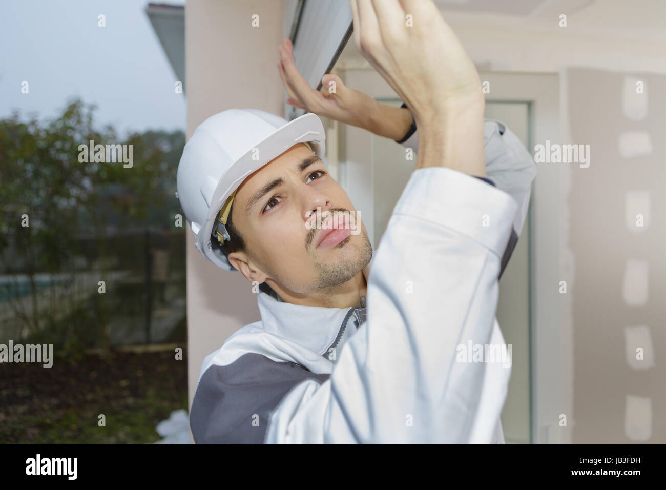 young man taping up windows in for a hurricane Stock Photo Alamy