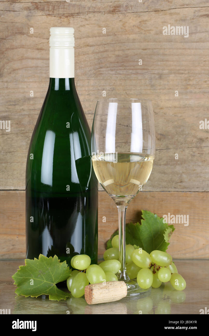 Weißwein in Flasche und Weinglas vor einem Holzhintergrund Stock Photo