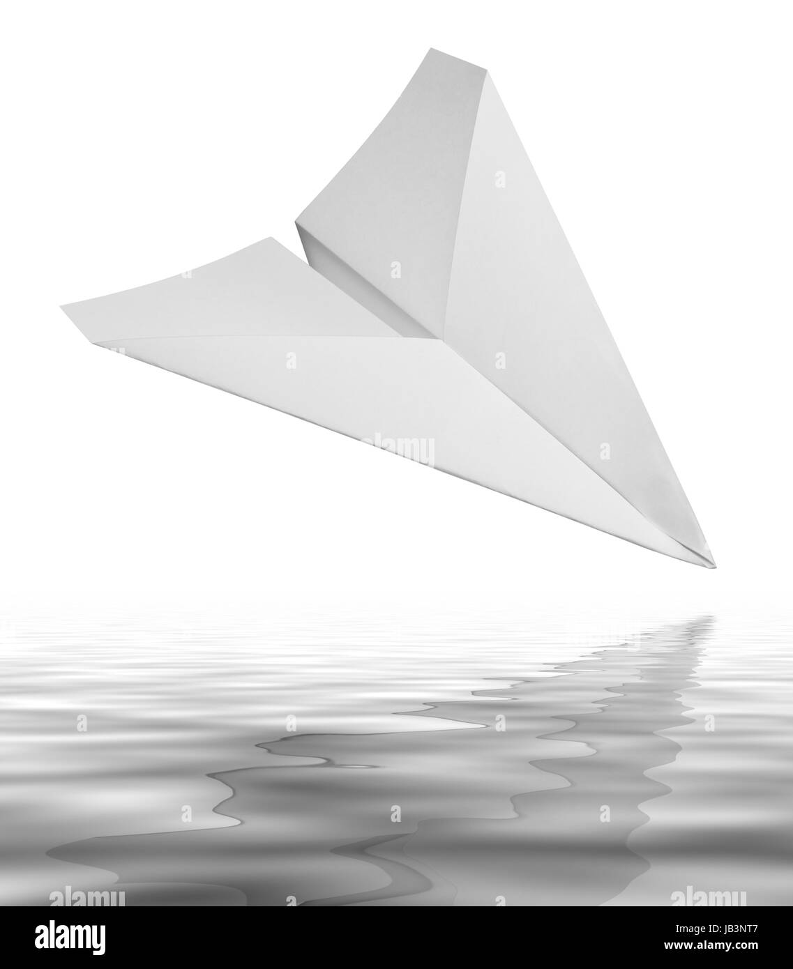 falling white paper plane on reflective water surface in white back Stock Photo