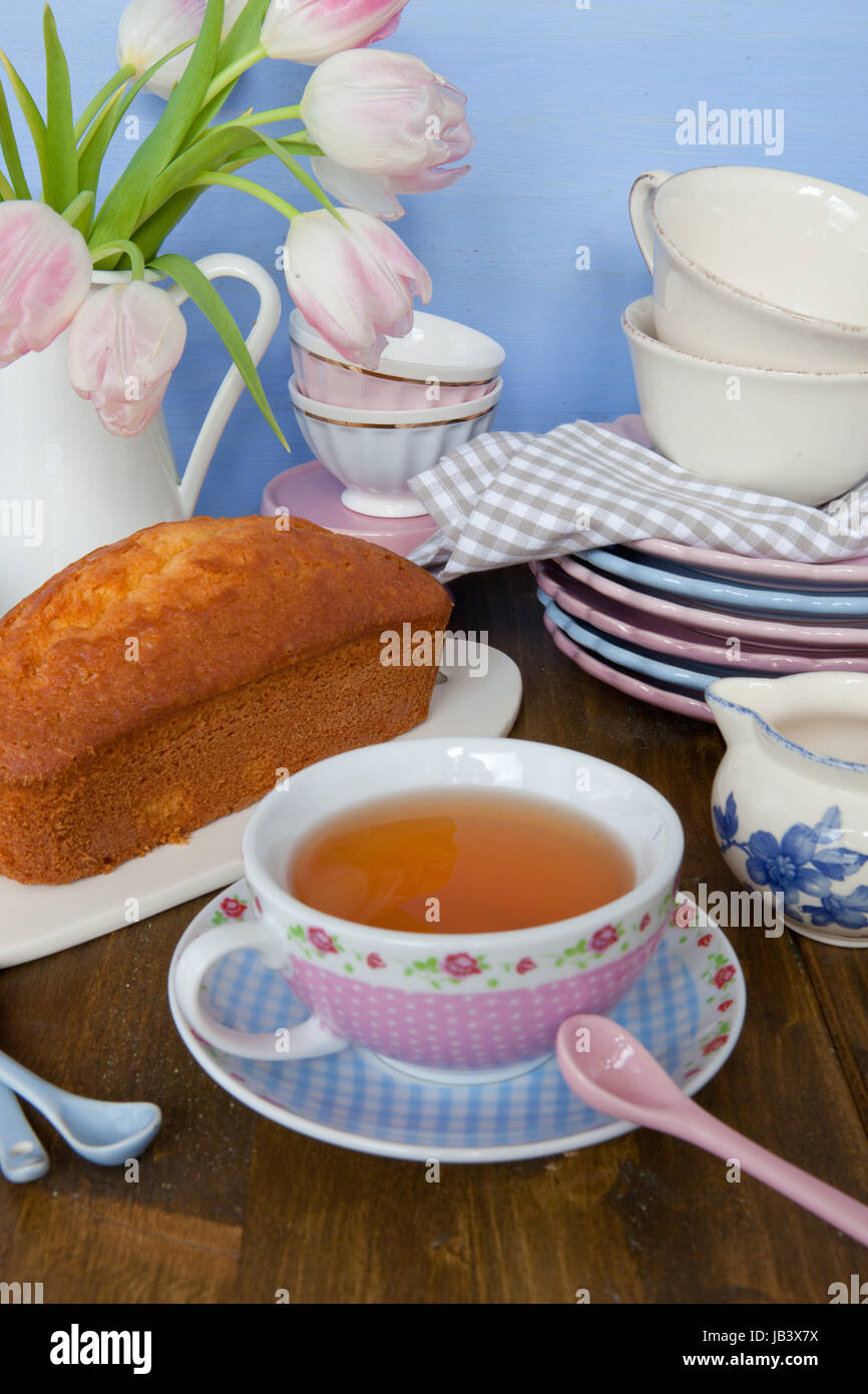 Sandkuchen und Tee auf buntem Geschirr Stock Photo