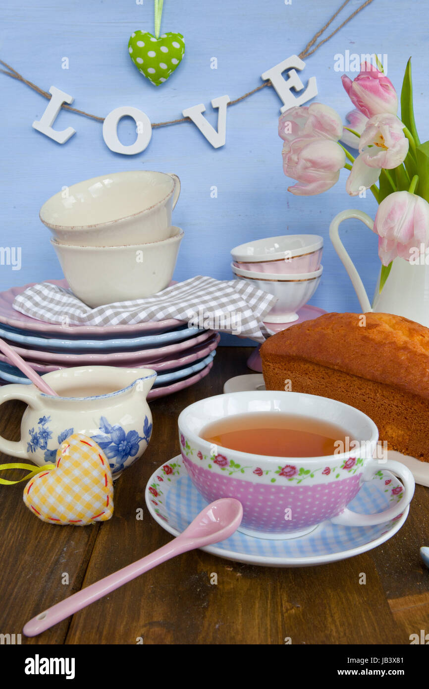Sandkuchen und Tee auf buntem Geschirr Stock Photo