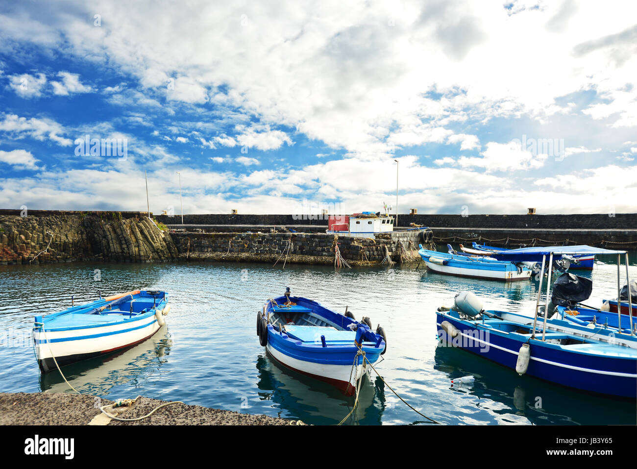 Fishing Boat, color blue white, moored along the quay on a cloudy day Stock Photo