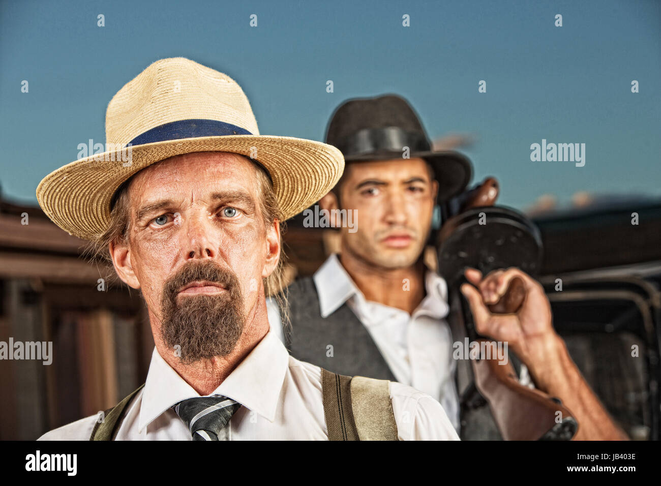 Pair of 1920s vintage gangsters in hats outside Stock Photo