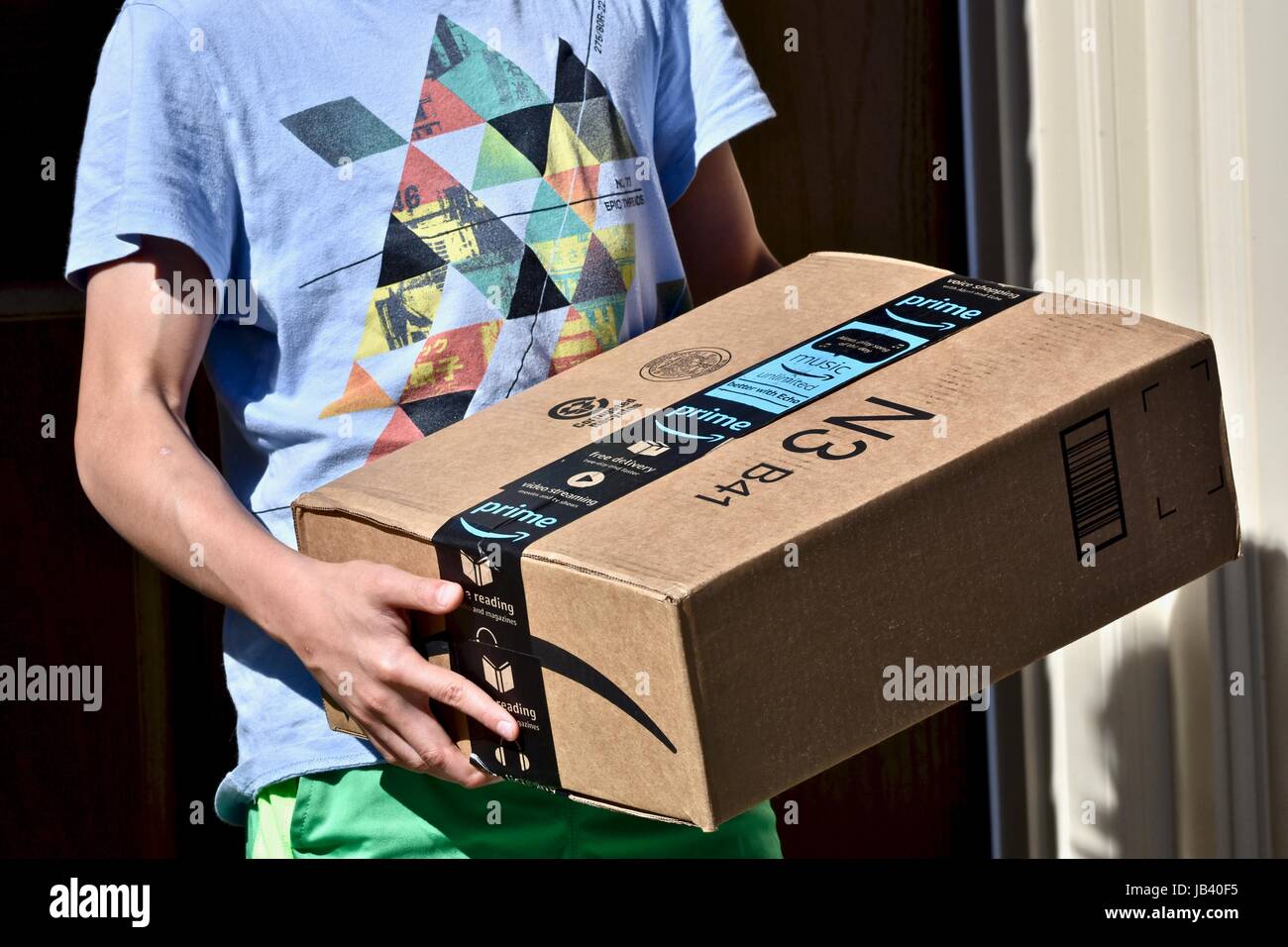 Picking up an Amazon Prime package box that was delivered to the front