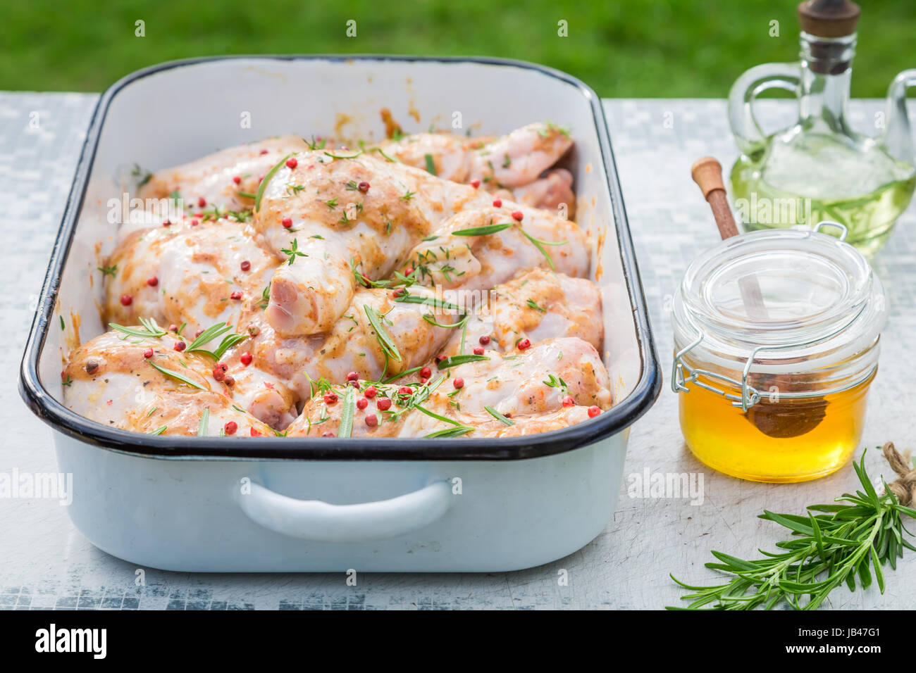 Seasoning chicken legs with herbs and honey for grill Stock Photo Alamy