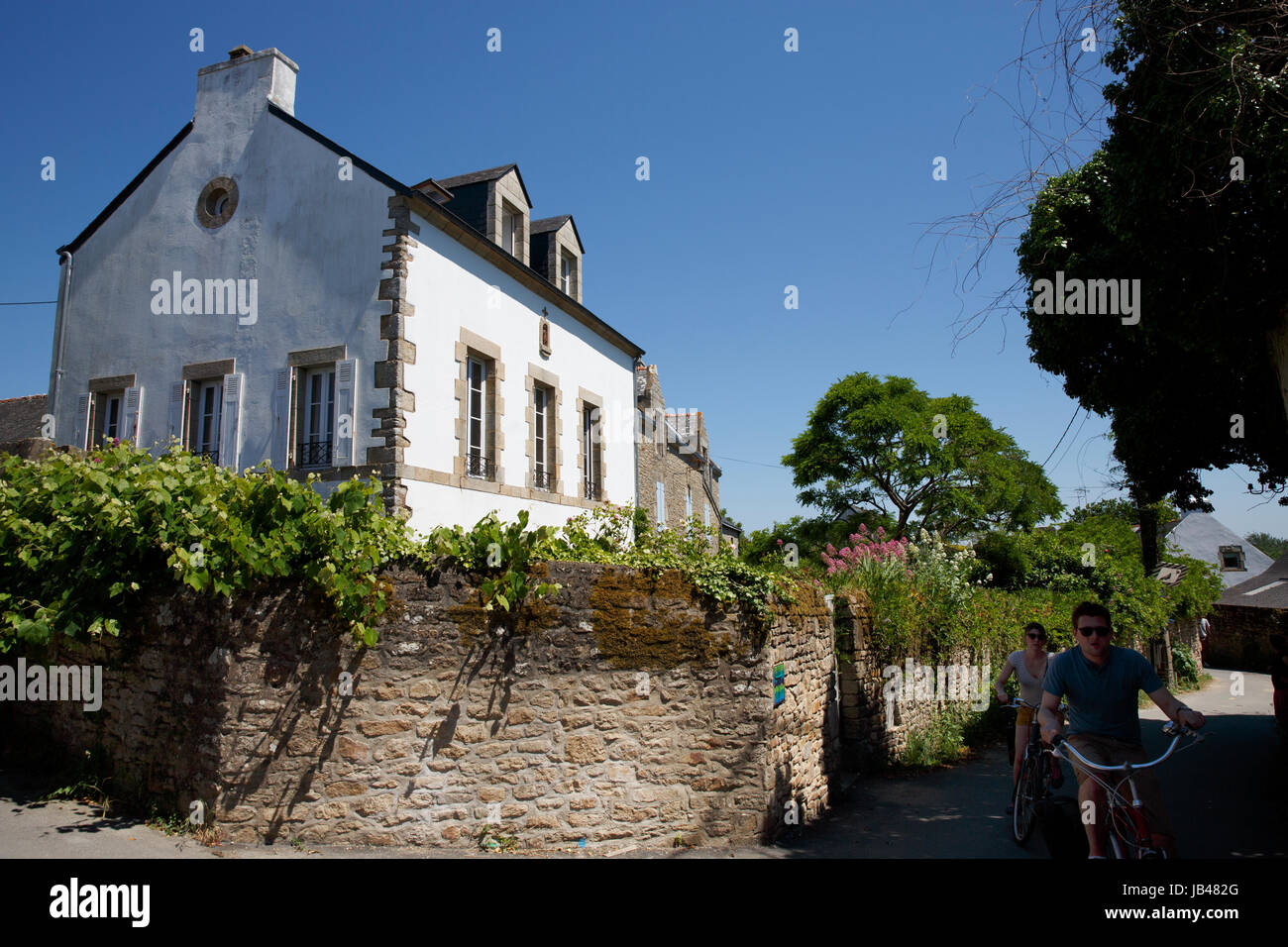 House, country lane, bicyclists, Ile aux Moines, Brittany, France Stock Photo