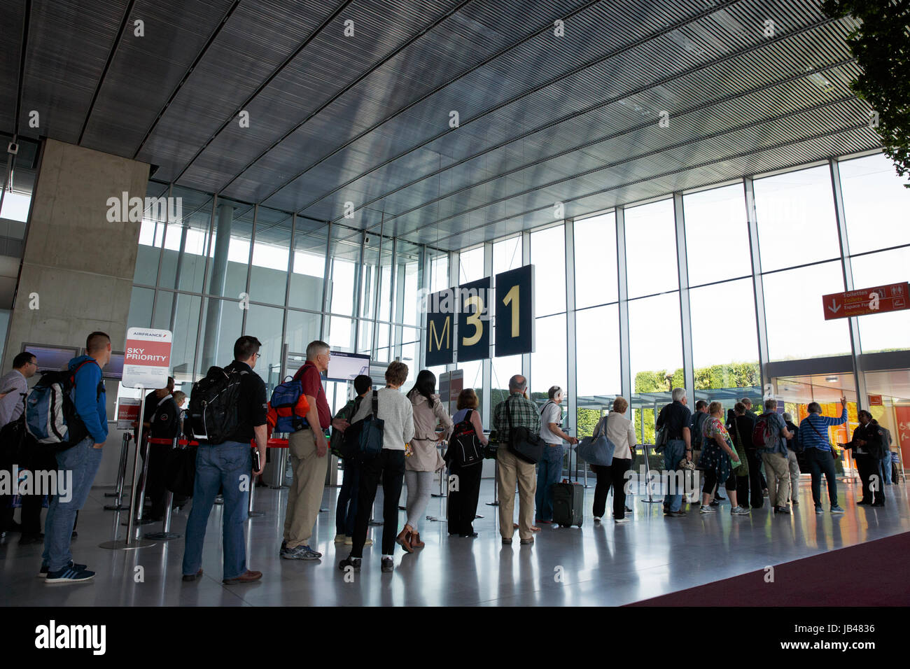Passengers waiting to board a flight at Roissy Charles de Gaulle Airport Stock Photo