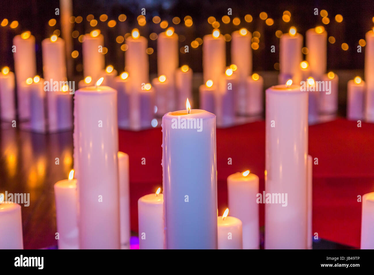 burning big candle in different size with flame Stock Photo