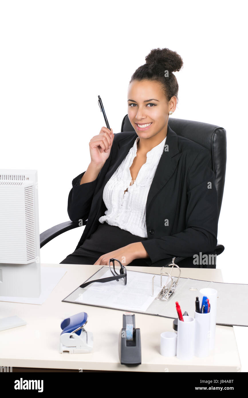 Junge, hübsche Angestellte sitzt am Schreibtisch im Büro und hält einen Stift Stock Photo